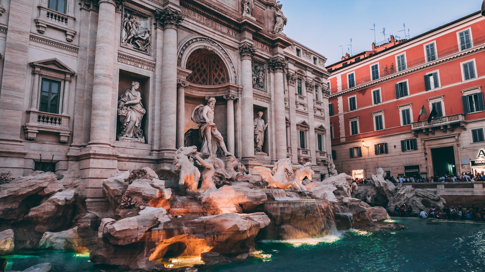 The iconic Trevi Fountain in Rome, a masterpiece of Baroque architecture, captured at dusk.