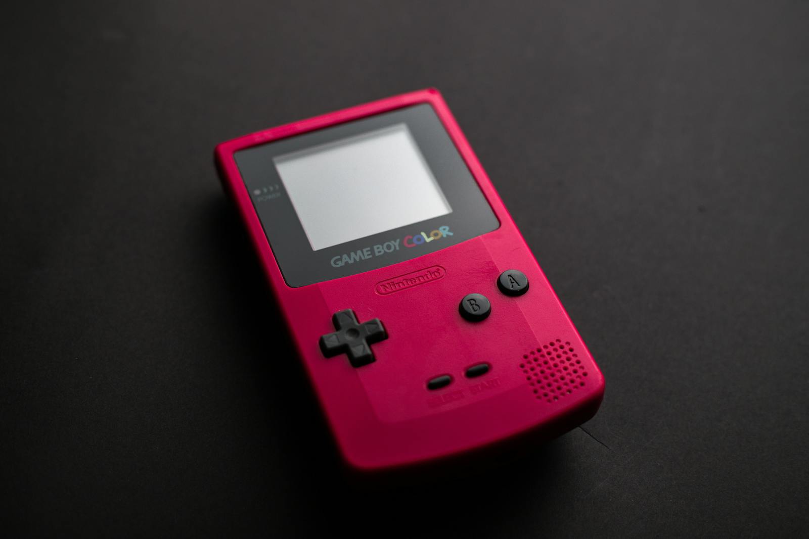 Close-up shot of a red Game Boy Color, showcasing nostalgic gaming culture.